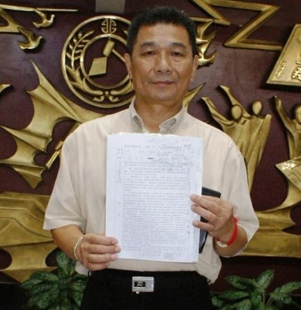 Депутат Городского совета Чэн Чинь-Лун, инициировавший принятие резолюции, держит в руках текст резолюции