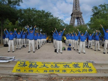 Группа практикующих выполняет упражнения Фалуньгун рядом с Эйфелевой башней