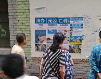В городе Наньчан провинции Цзянси прохожие читают плакат, вывешенный последователями Фалуньгун