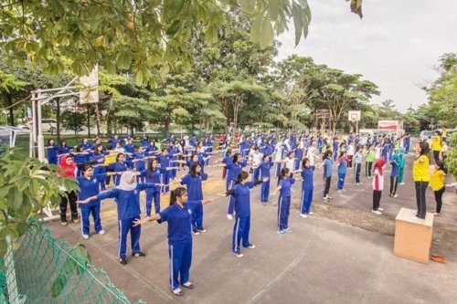 Сто двадцать студентов и преподавателей бизнес-школы в Батаме осваивают упражнения, август 2016 года. Индонезия