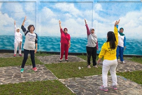 Практикующие обучают желающих упражнениям Фалуньгун в торговом центре и возле него, Индонезия.