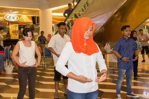 Практикующие обучают желающих упражнениям Фалунь Дафа в торговом центре, Индонезия