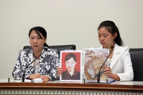 Чи Лихуа (слева) и её дочь Сюй Синьян (справа) свидетельствуют на форуме. Сюй держит две фотографии своего отца Сюй Давэя. Фотография слева была сделана до ареста, а справа – после его освобождения