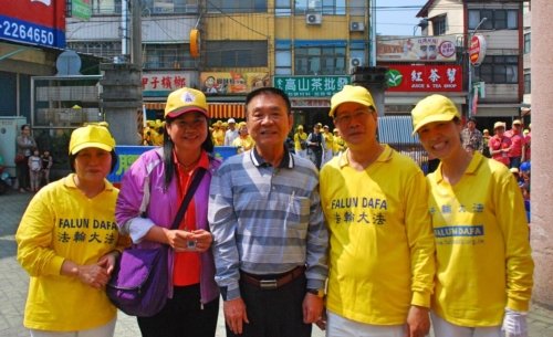Директор начальной школы Мэйшань Чиу Вэнь-Фэн (вторая слева) и глава городской администрации Лю Хун-Вэнь (в центре) с последователями Фалуньгун