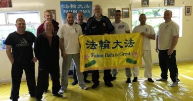 После обучения упражнениям учащиеся школы боевых искусств сфотографировались у плаката с надписью «Фалунь Дафа – великий» и выразили поддержку Фалуньгун