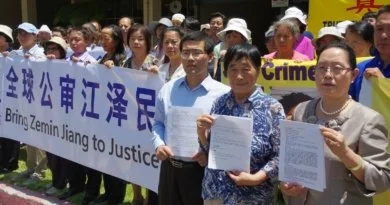На митинге в Лос-Анджелесе последователи Фалуньгун Чжан Цзинь, Ли Шуин и Ши Чжэнхуа (слева направо) держат в руках копии исковых заявлений, поданных против Цзян Цзэминя, 2015 г.