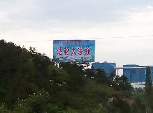 На рекламном щите написано: "Фалунь Дафа - это хорошо!"
