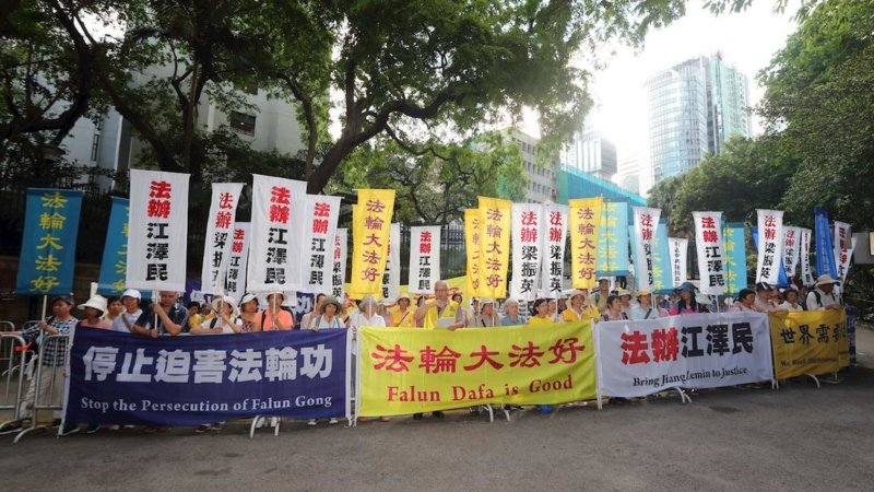 Во время визита лидера Китая Си практикующие Фалуньгун демонстрируют плакаты, призывающие остановить преследование Фалуньгун и привлечь бывшего главу КПК Цзян Цзэминя к правосудию