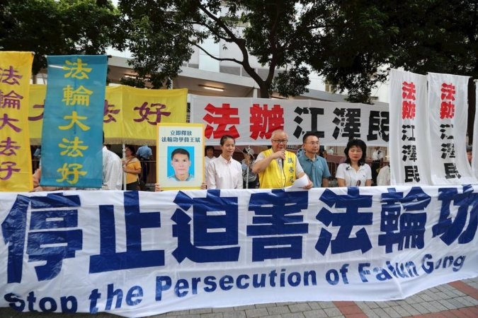 Во время визита президента Китая Си практикующие Фалуньгун демонстрируют плакаты, призывающие остановить преследование Фалуньгун и привлечь бывшего главу КПК Цзян Цзэминя к правосудию