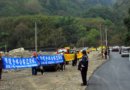 Последователи Фалуньгун стоят с плакатами вдоль дороги, по которой следует автоколонна Сюй Гуанчуня
