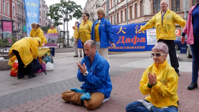 Кирилл (сидит в центре) на мероприятии последователей Фалуньгун демонстрирует упражнения