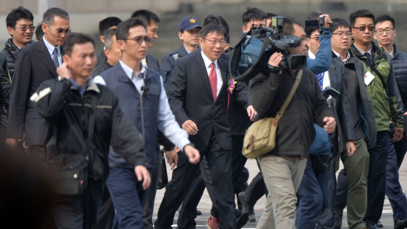 Мэр Тайбэя доктор Ко Вэнь Цзе (в центре, в красном галстуке) окружён репортёрами в первый день пребывания в должности, 25 декабря 2014 г. Фото: с сайта Epoch Times