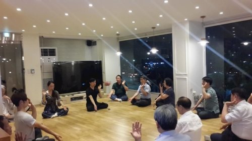 Участники 26-го девятидневного семинара Фалунь Дафа изучают медитативное упражнение