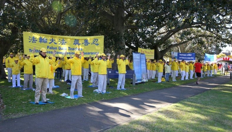 Плакаты Фалуньгун на пути участников пробега и демонстрация упражнений Фалуньгун