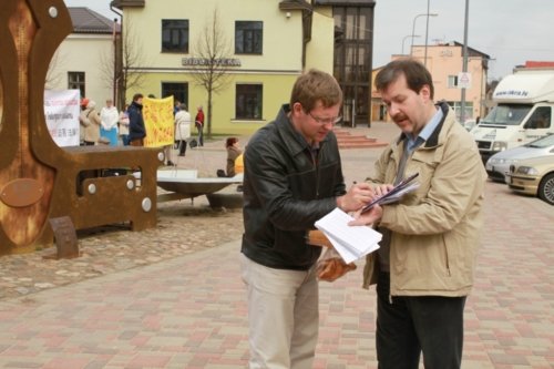 Прохожие подписывают петицию в поддержку подачи исков к Цзян Цзэминю. Латвия, 2016 г
