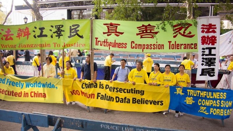 Практикующие Фалуньгун держат транспаранты и плакаты, призывающие мировых лидеров обратить внимание на 18-летнее преследование Фалуньгун в Китае и помочь остановить деятельность, нарушающую права человека.
