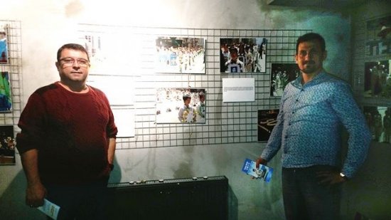 Член городской администрации Эндер Уйсал и его друг на фотовыставке. Фото: minghui.org