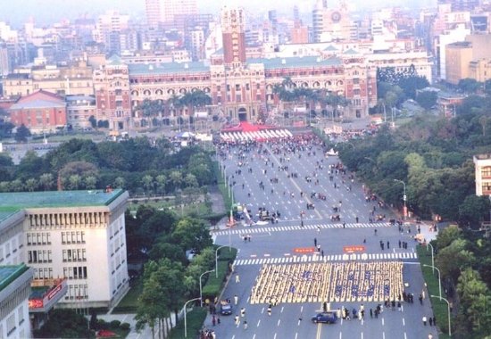 Практикующие сформировали иероглифы «Закон исправляет человеческий мир» во время церемонии поднятия флага перед президентским дворцом во время Нового 2002 года