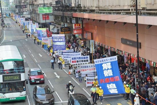 Во время парада практикующие несли плакаты, которые призывают прекратить преследование и привести к правосудию его главных виновников