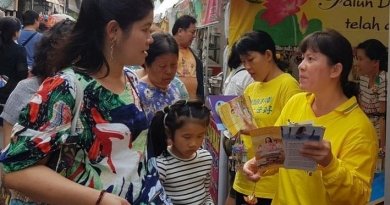 Туристы слушают практикующего, рассказывающего о практике Фалуньгун