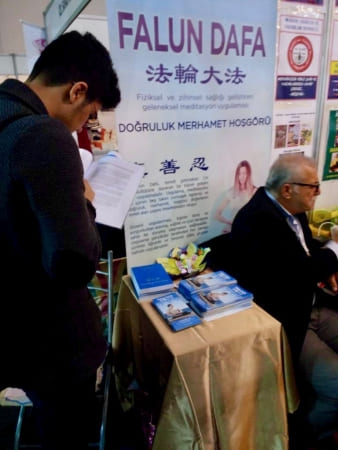 Студент подписывает петицию, призывающую прекратить преследование Фалунь Дафа в Китае Фото: minghui.org