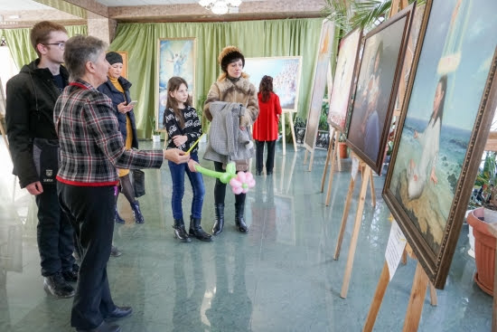 Посетители выставки внимательно рассматривают картины