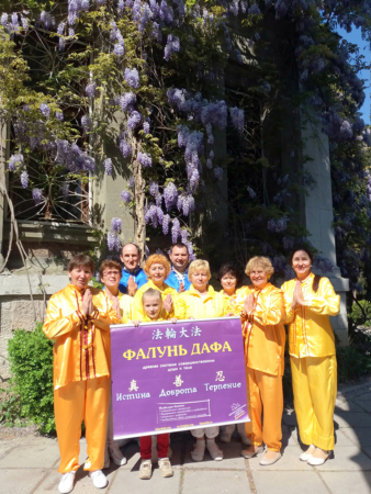 Под цветущей лианой глицинии ученики из Крыма поздравляют Мастера Ли Хунчжи с Днём рождения и Днём Фалунь Дафа