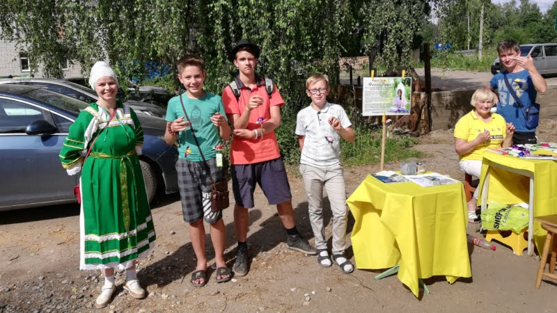 Местные ребята Серёжа и его друг Максим с практикующими Фалуньгун во время празднования Дня города Пестово, 2019 год