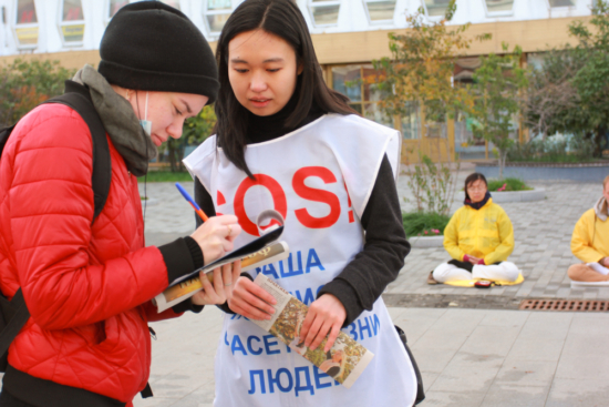 Сочувствующие подписывают Петицию против принудительного извлечения органов у последователей Фалуньгун