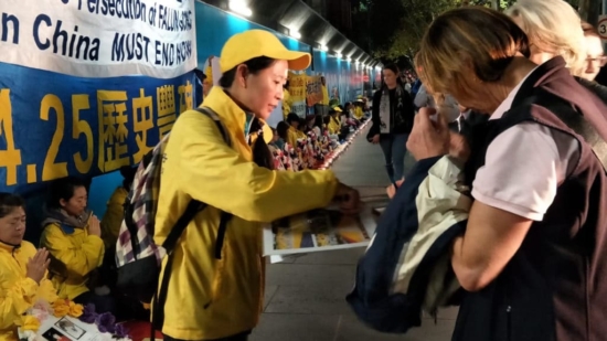Во время мирной акции протеста в Австралии Ангела рассказывает прохожим о преследовании Фалуньгун в Китае