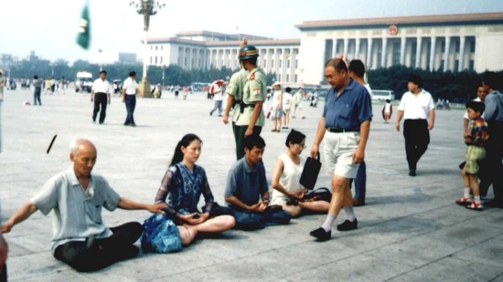 Ангела, практикующая Фалуньгун (в центре), медитирует на площади Тяньаньмэнь, Китай, 2001 г.