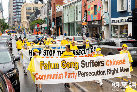 По случаю 22-й годовщины противостояния преследованиям в Китае 17 июля 2021 года практикующие Фалуньгун в центре Торонто (Канада) провели шествие в поддержку репрессируемых китайских единомышленников