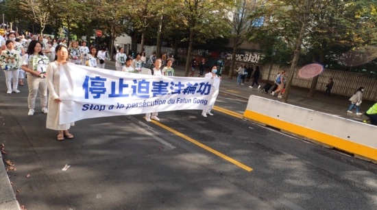 Плакат, призывающий прекратить репрессии Фалуньгун в Китае. Парад в Париже, 2021 г.
