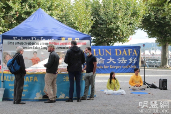 Люди разговаривают с практикующими, чтобы больше узнать о Фалунь Дафа