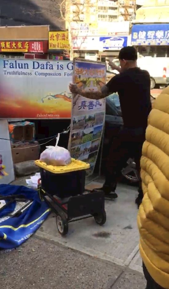 Чжэн Буцю разрывает плакат Фалуньгун. (Фотография предоставлена практикующим Фалуньгун)