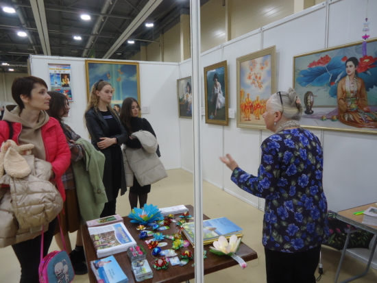 Посетители выставки слушают рассказ гида о картинах