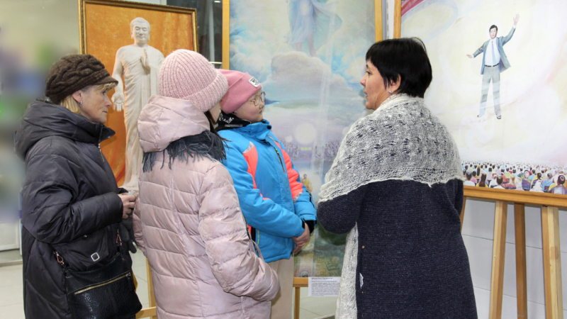 Посетители Художественной выставки «Истина, Доброта, Терпение» внимательно слушают гида. Иркутск, декабрь, 2022 г.