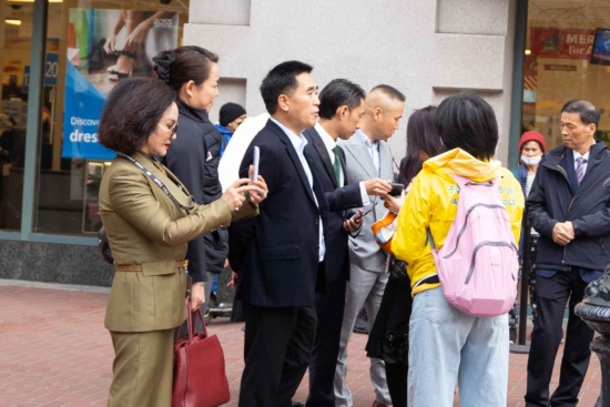 Практикующие (в жёлтом) беседуют с китайскими делегатами о Фалуньгун и о преследовании в Китае