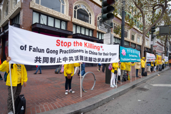 Практикующие Фалуньгун держат плакаты с информацией о преследовании в Китае