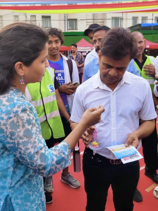 Практикующая Фалунь Дафа даёт актёру Раджпалу Ядаву информационные материалы и дарит хрустальный лотос