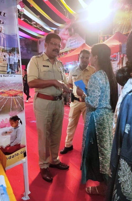 Практикующая предлагает заместителю комиссара полиции города Мумбаи Винаяку Дхакале информационные материалы Фалунь Дафа